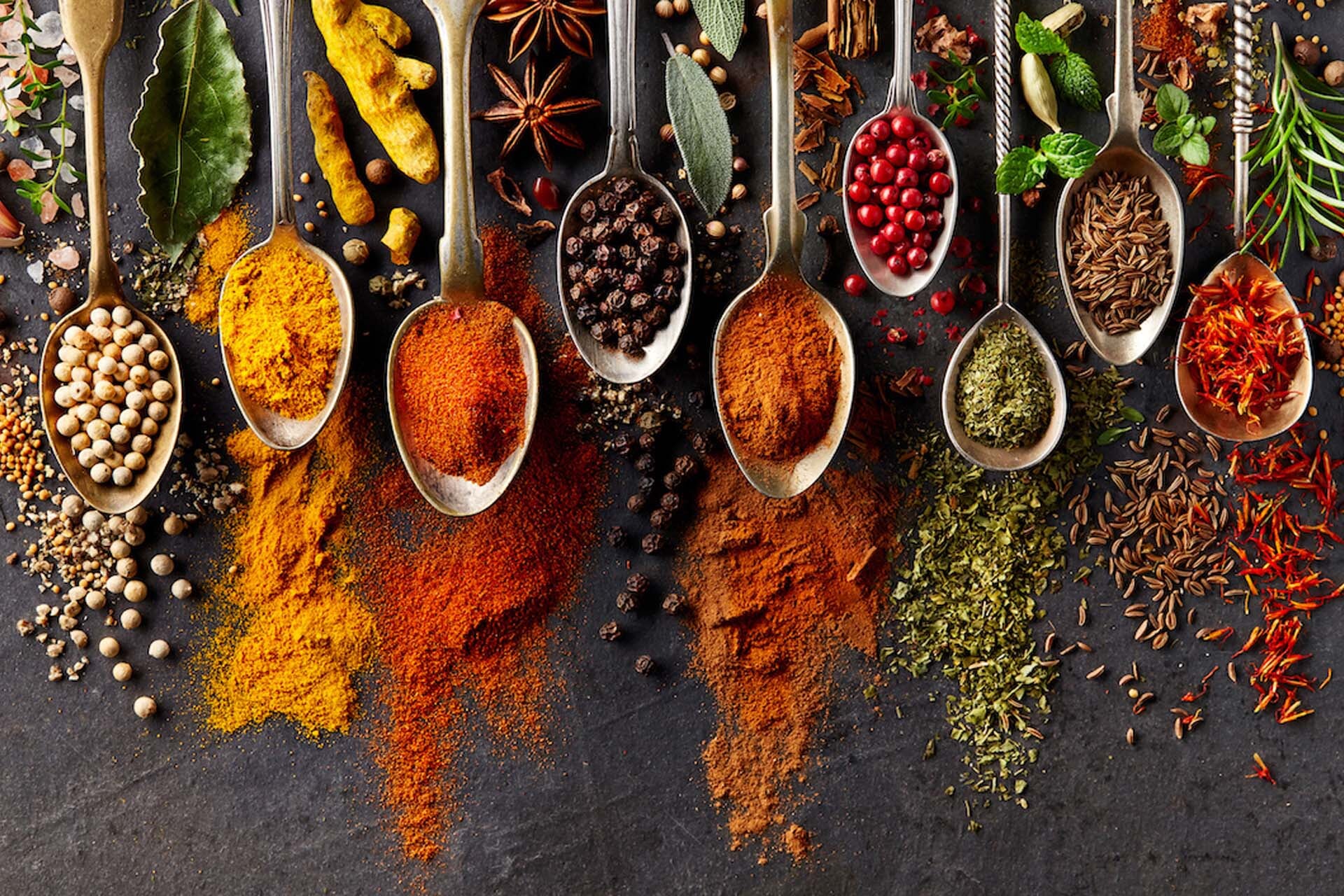 Assorted spices and seeds in wooden spoons
